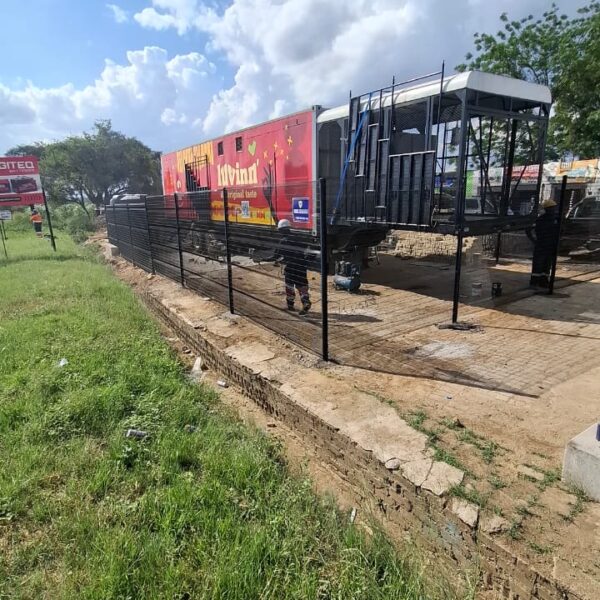 Partially installed black clearview mesh fence along the boundary of the Chicken Inn site in Chitungwiza