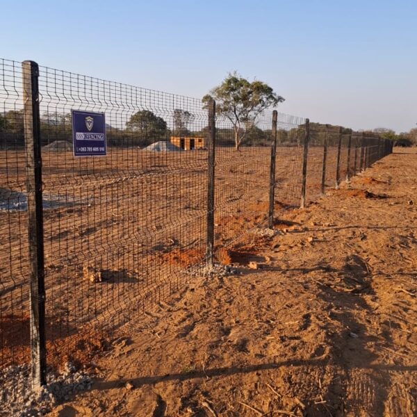Clearview anti climb mesh security fence on steel posts running along a cleared boundary at Mbalabala